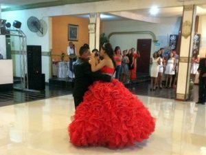 The quinceañera herself, enjoying her first dance as an adult woman with her father.